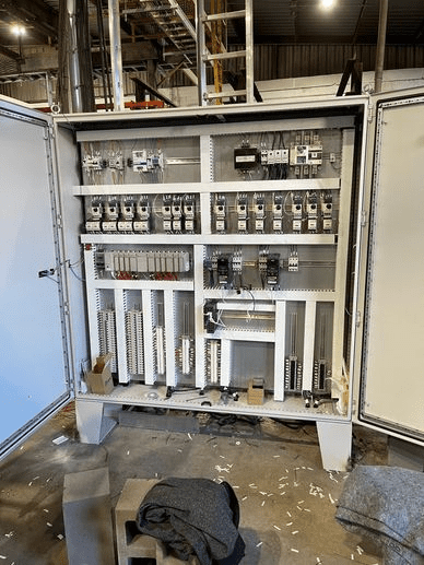 A large electrical panel with many wires and boxes.