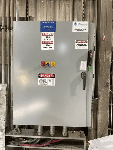 A gray electrical panel with multiple tags on it.